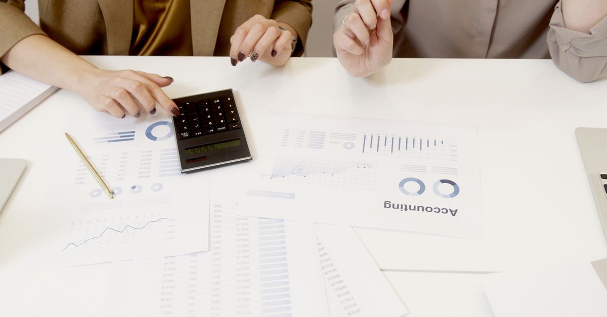 Two professionals analyzing financial documents with a calculator. — illustrating expenses reciept