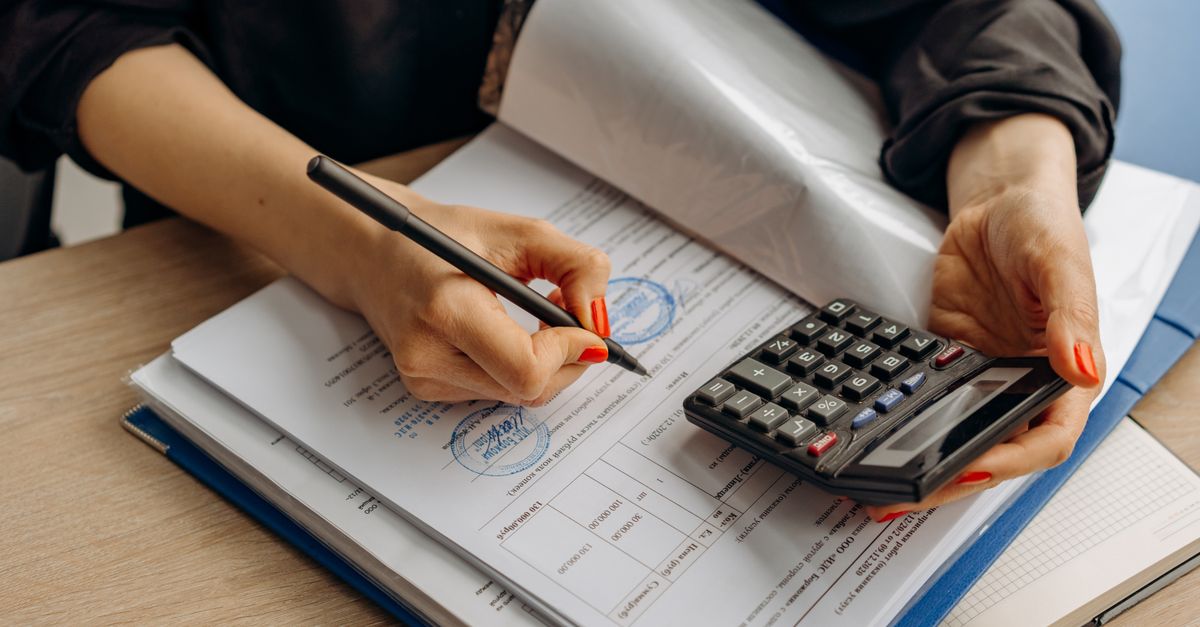 An accountant using a calculator and signing paperwork, showcasing financial analysis. — illustrating how can i make a fake receipt