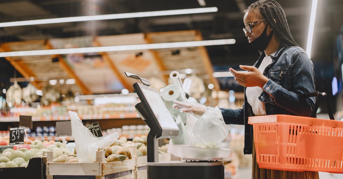 A woman with a mask shops and weighs groceries in a modern supermarket setting. — illustrating grocery store receipt