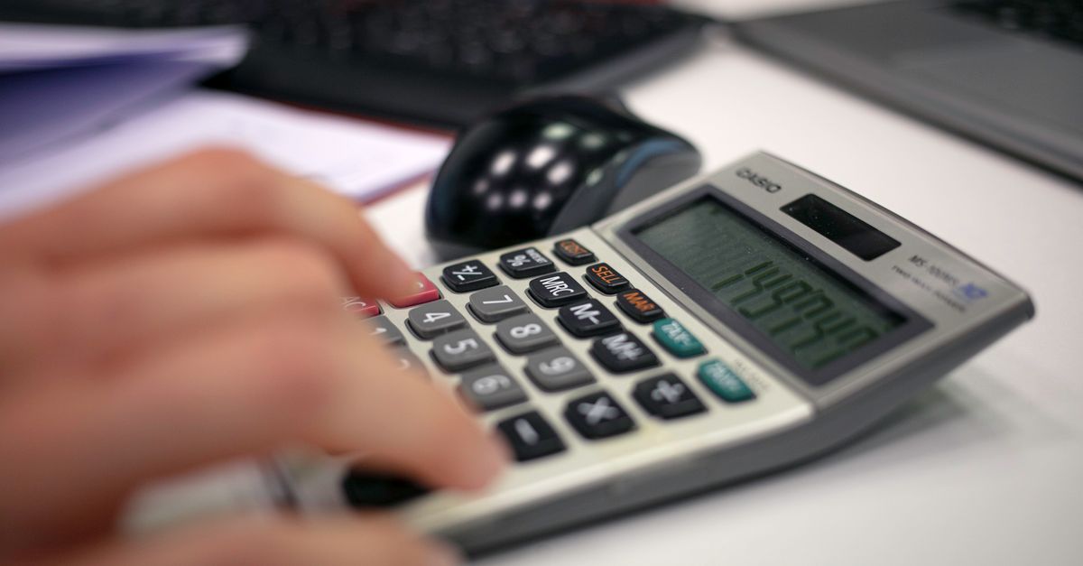 Close-up of a hand using a calculator on an office desk for accurate calculations. — illustrating expense receipt