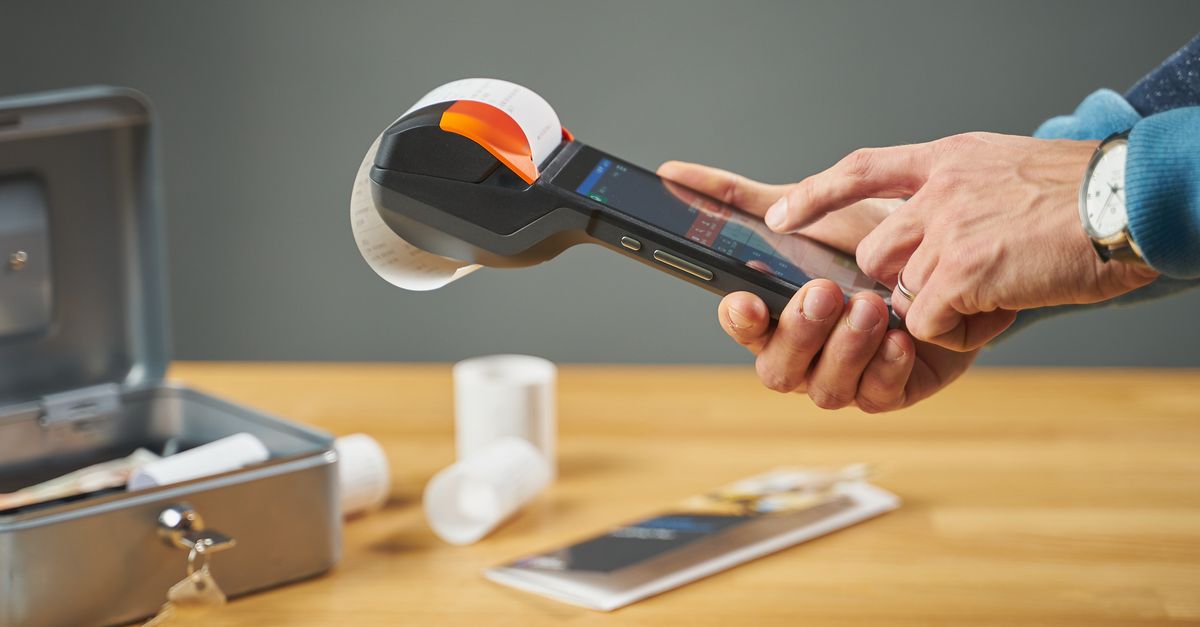 Hands operating a portable receipt printer with printed receipts on a wooden table. — illustrating receipt creator online